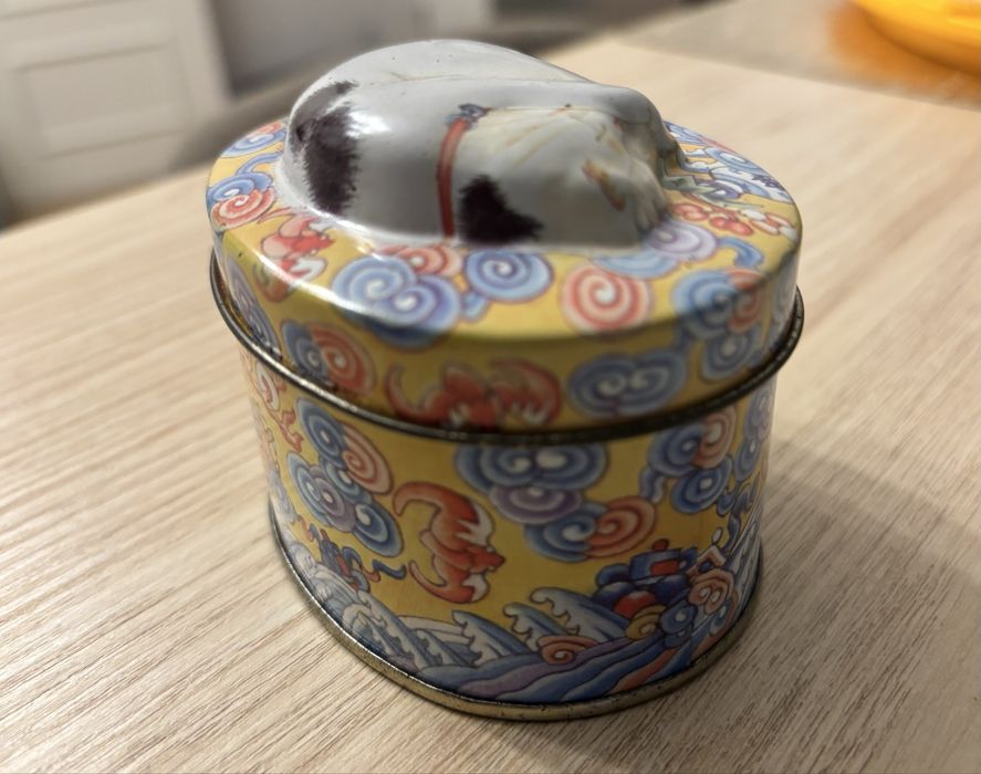 Caixa de lata oval, com gato em relevo