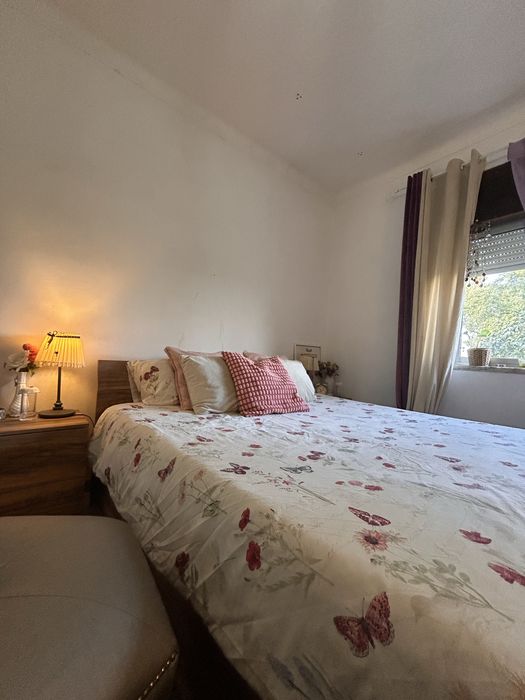 Quarto casal com mesas de cabeceiras e cómoda.