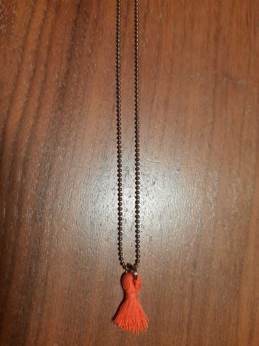 Fio com pendente de linha côr de laranja. 2,50 eur