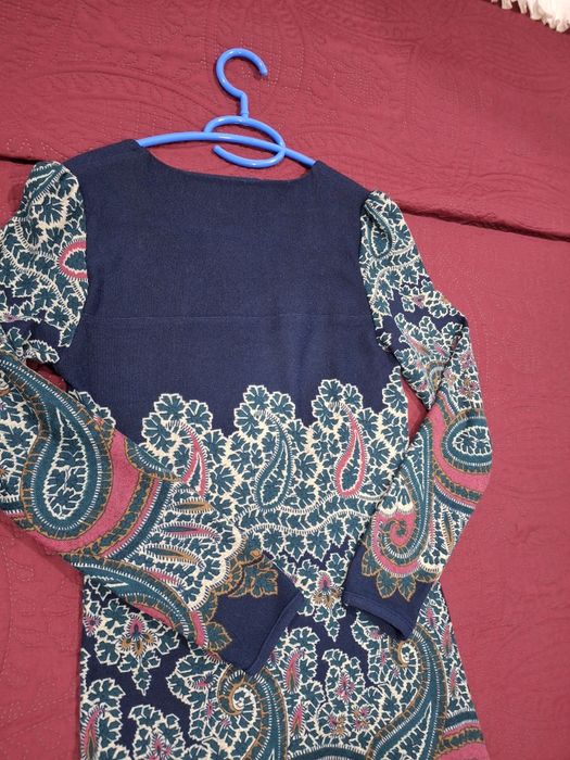 Vestido com um padrão floral e paisley vibrante.

- Decote redondo.
- Mangas compridas.
- Padrão paisley em azul, verde e rosa.