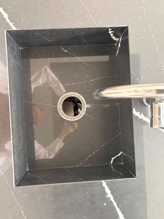 Cozinha de exposição com ilha — branco brilhante e tampo preto veiado