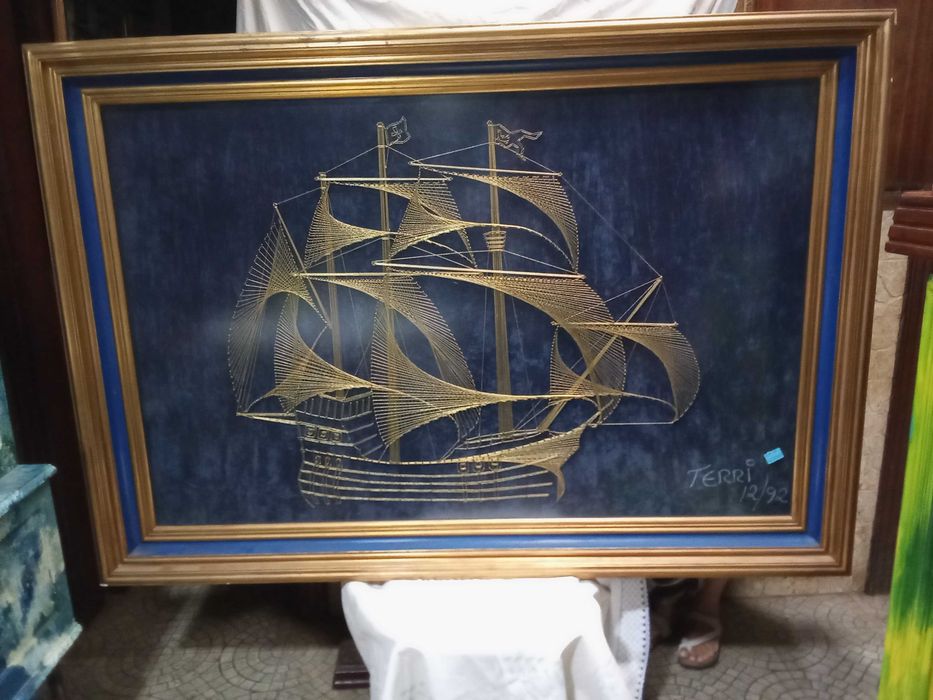 Quadro construído com fio dourado a representar uma caravela Portuguesa