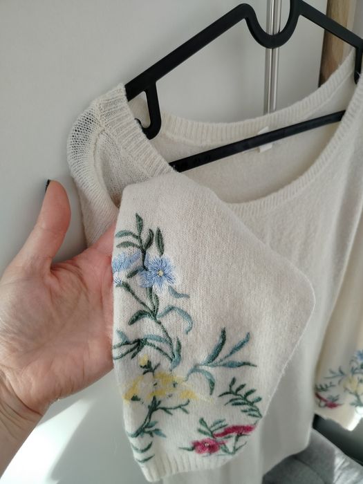 Jasny swetr z haftowanymi rękawami. Rozmiar L/XL