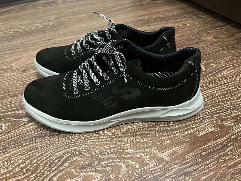 Чорні кросівки з м’якого матеріалу на світлій підошві.