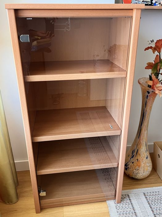 Estante  de madeira carvalho e com porta de vidro.