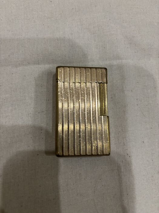 Vendo isqueiro de luxo vintage S.T. Dupont Paris, modelo clássico Ligne 1 com o icónico padrão guilloché de linhas verticais caneladas.