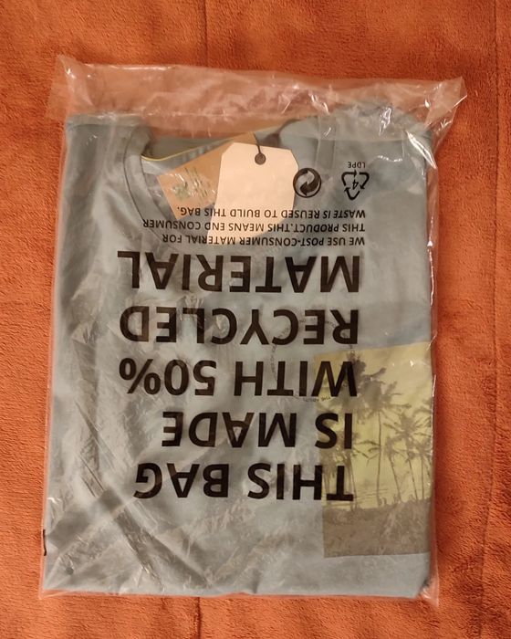 T-shirt verde azulado com desenho frente e verso.