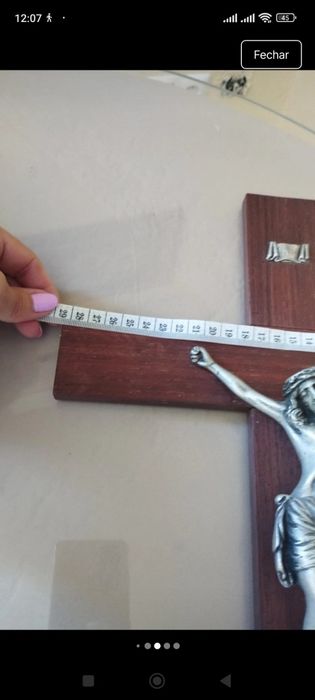 Crucifixo de mesa composto por uma cruz de madeira escura com uma base escalonada de vários níveis.A figura tridimensional do corpo de Cristo (corpus)