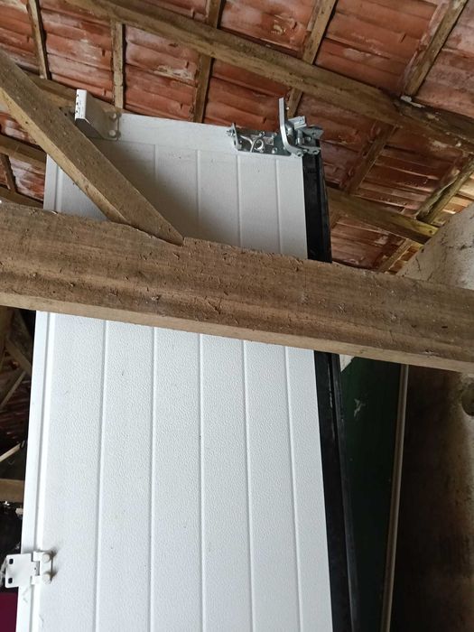Portão seccionado vertical de pavilhão branco por dentro verde por fora com motor.