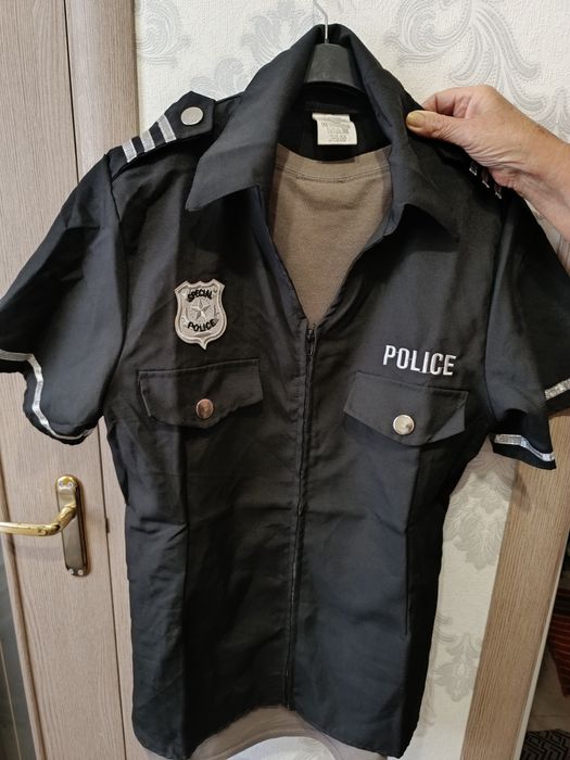 карнавальный костюм "Police Officer" от бренда Widmann .Рубашка застегивается на молнию и украшена нашивкой "Special Police" на груди.