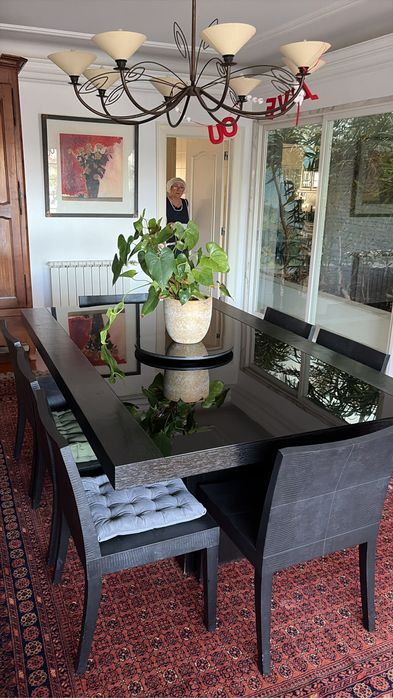 Mesa de jantar da loja Artefacto Brasil, em madeira macica e tampo de vidro. Preta.
