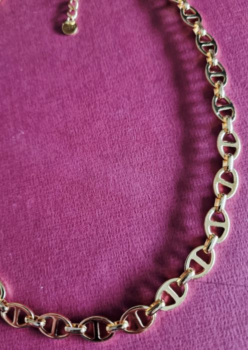 Colar/gargantilha dourada, em aço inoxidável. Tem extensor