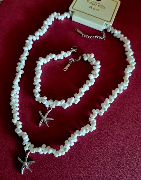Conjunto branco (colar e pulseira), em aço, com estrela do mar prateada.