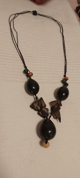 Vários colares de praia feitos de sementes polidas e outros materiais