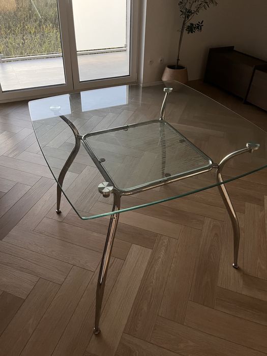Szklany stól z metalowymi nogami