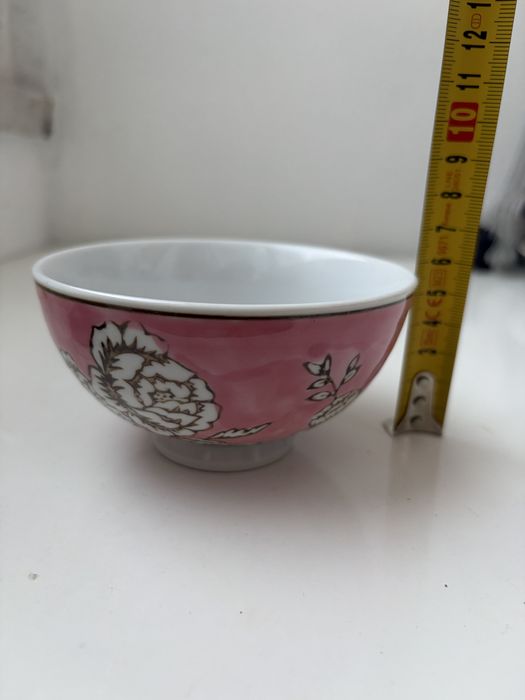 Esta é uma taça de chá cor-de-rosa com estampado de peónias.