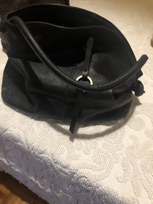 Mochila em pele castanha e bolsa preta . Ambas em pele