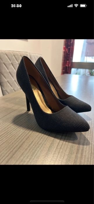 Sapatos de salto alto pretos com padrão brilhante dourado.