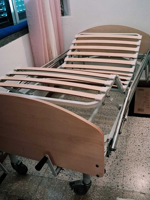 Cama articulada com grades rebatíveis e manivelas manuais (cabeceira e pés).