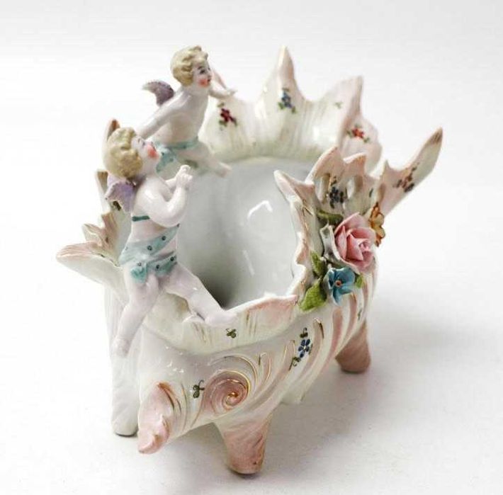Taça em porcelana modelada em forma de búzio com querubins e flores