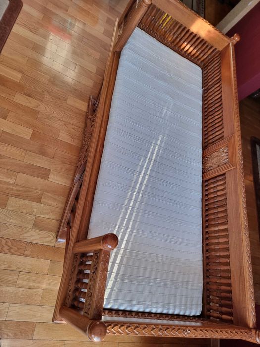 Zabytkowa sofa z drewna tekowego.