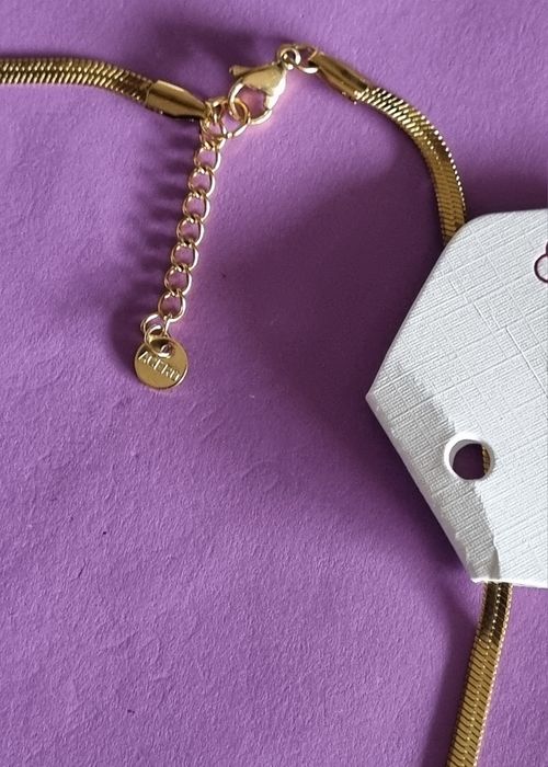 Colar dourado, em aço, malha fita com ponto de luz. Tem extensor