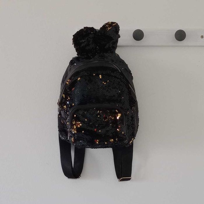 Mochila preta e dourada com orelhas de coelho