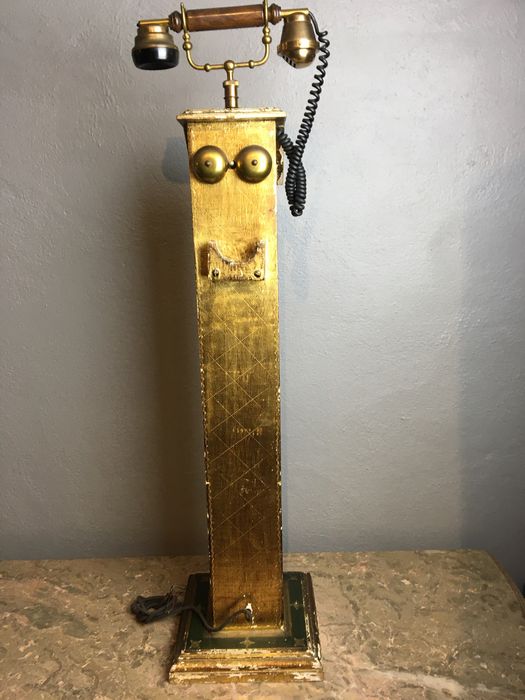 Telefone antigo em coluna pintado em talha dourada