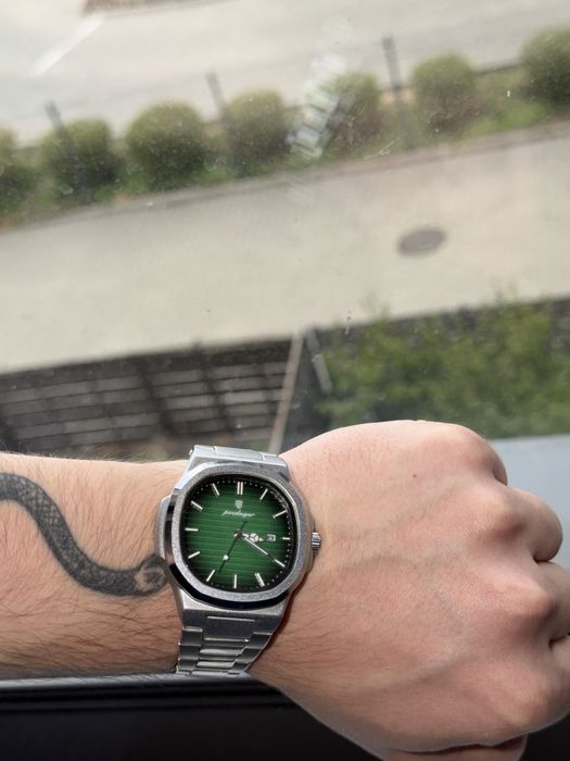 Zegarek na bransolecie z zieloną tarczą.