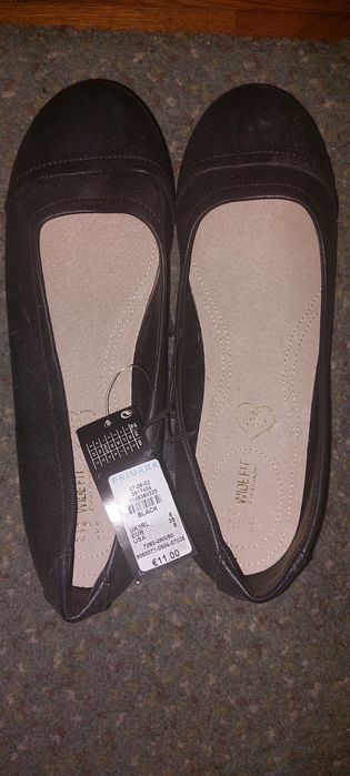 Ténis brilhantes novos e sapatos pretos novos