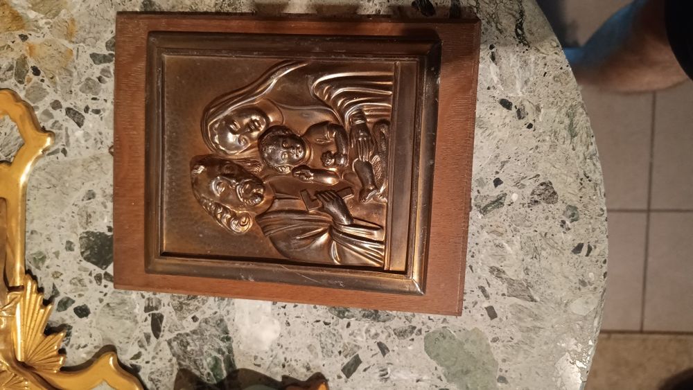 Żeliwna płaskorzeźba  wyeksponowana na dębowej desce