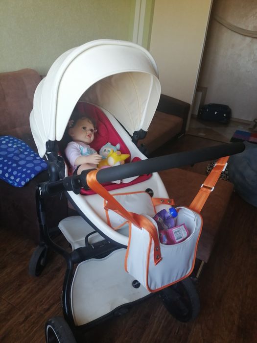 Коляска для дитини, білого кольору.