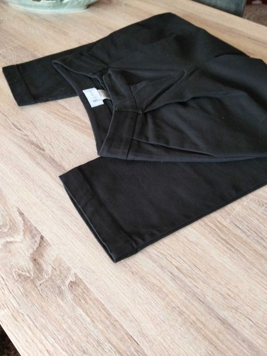 Calças pretas com bolsos metidos.