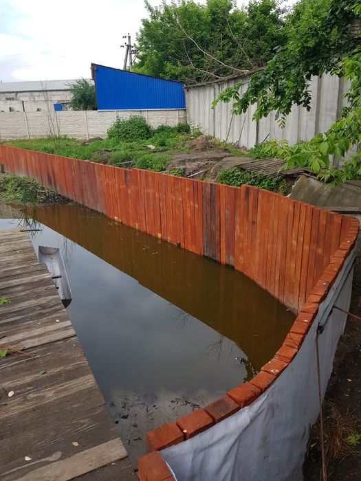 Укрепление берега.Укрепление берега дубовыми бревнами.Габионы.