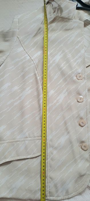 blazer feminino de cor bege com um padrão abstrato claro,