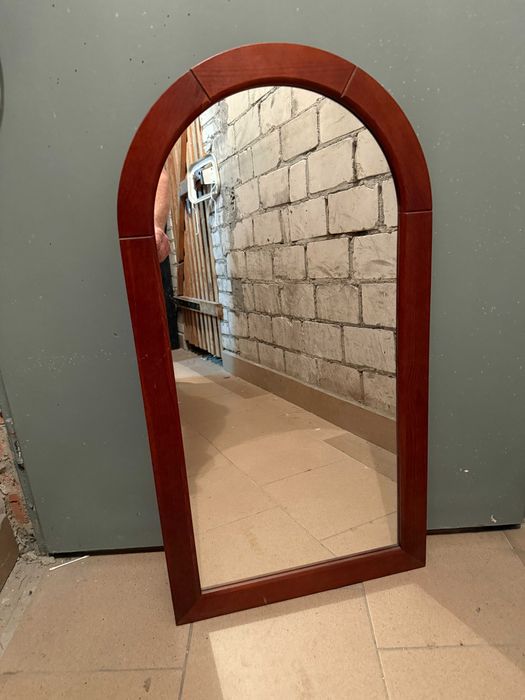 Lustro na ścianę w drewnianej ramie.