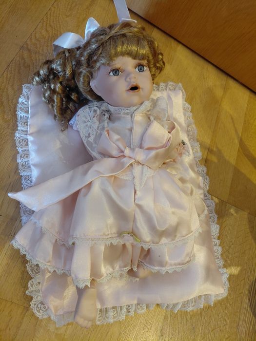 Boneca de porcelana com almofada