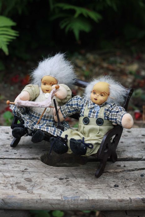 Dwie lalki siedzące na ławce Babcia i Dziadek