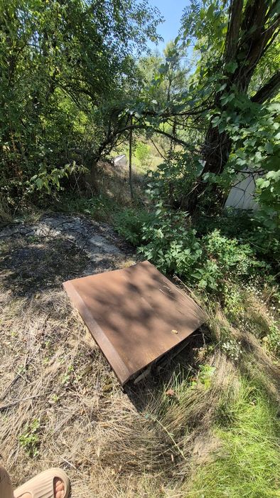 Будинок з джерельною водою на березі річки, асфальтована дорога