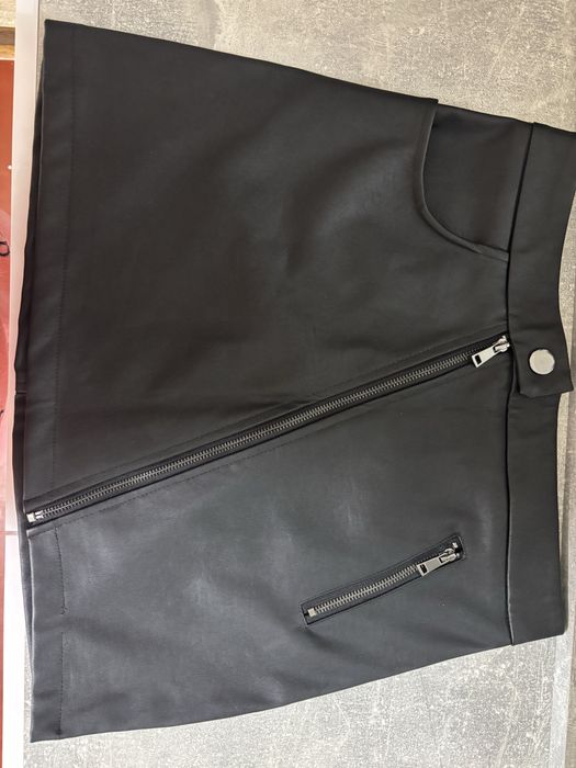 Чорна мініспідниця з екошкіри з асиметричною блискавкою.