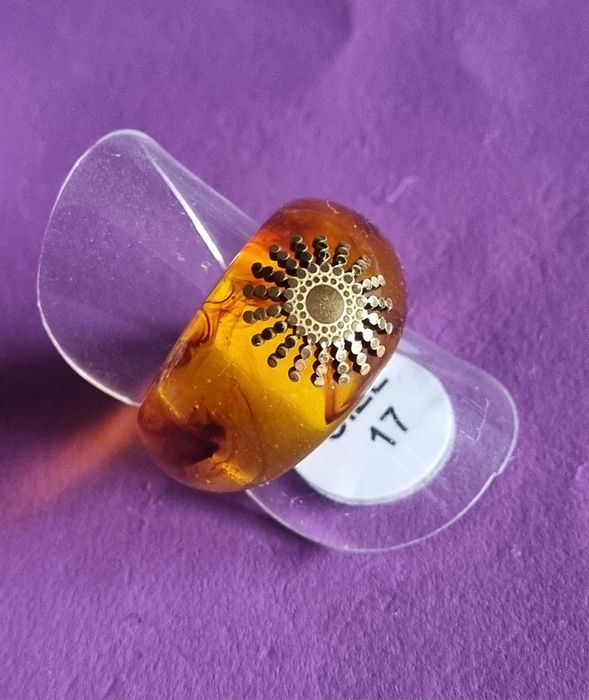 Anel em acrílico castanho com sol dourado, em aço. T17