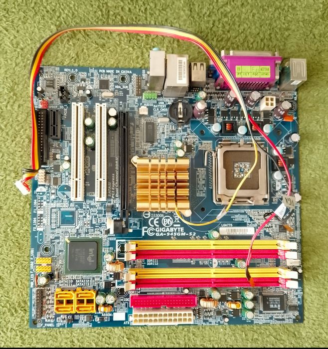 Płyta główna Gigabyte wraz z procesorem Intel Celeron głośniczkiem i kablami.