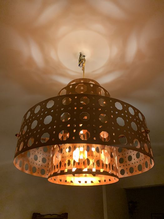 Lampa sufitowa, wiszaca w kolorze miedzianym.