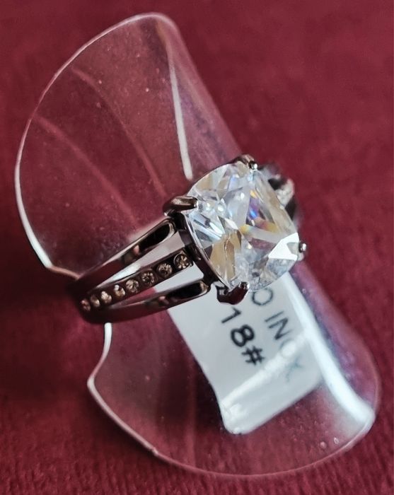 Anel prateado, em aço, com ponto de luz oval e 1 fiada de zirconias.18
