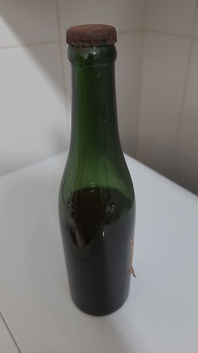 Antiga garrafa de cerveja gravada em alto relevo nas laterais