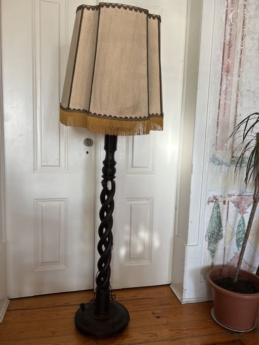 High-standing wooden floor lamp with carved details