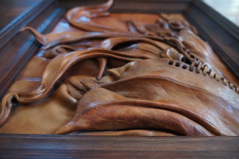 Obraz ze skóry w drewnianej ramie.