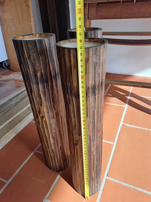 3 velas altas em tronco de madeira