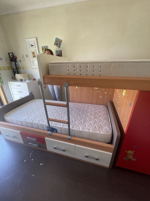 Quarto de criança com cama, secretaria e prateleira