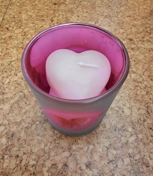 Copo em tons de rosa com três velas em formato de coração